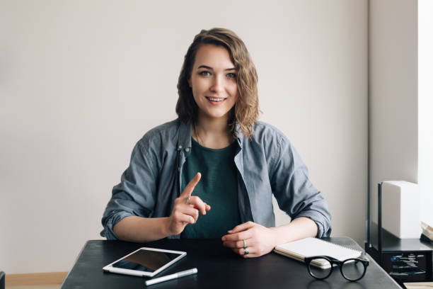 istock Young Professional Engaged in a Video Conference, Communicating with Confidence through a Web Camera from Office or Home. Life Coaching and Online Business Meeting Concept. 1499503574