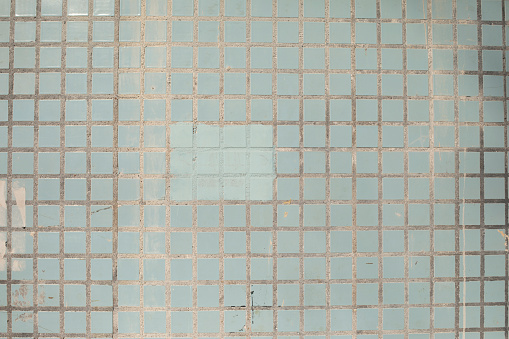 Tile wall. Blue tiles. Surface details. Crossing lines.