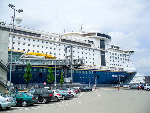Kiel, Germany - June 09, 2010: The ferry Color Fantasy of the shipping company Color Line has moored at the terminal in Kiel, Germany. The ship is being prepared for departure to Oslo in Norway. Numerous cars are ready to be loaded onto the ferry.