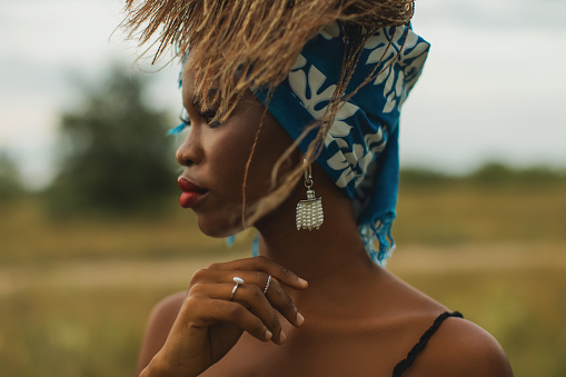 Beautiful woman in bandana outdoors. Authentic style. Summer fashion. Model with afro hairstyle. Stylish accessories.