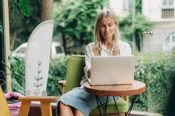 istock Young woman freelancer works remotely while sitting in a modern coffee shop. 1499511468
