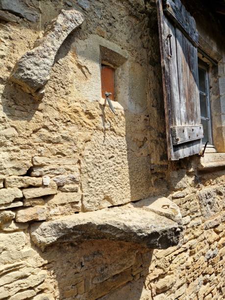 weathered stone wall with weathered wooden shutter in french village - european culture ancient architecture still life imagens e fotografias de stock