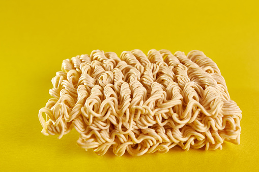 Instant vermicelli on a yellow background. Instant food.