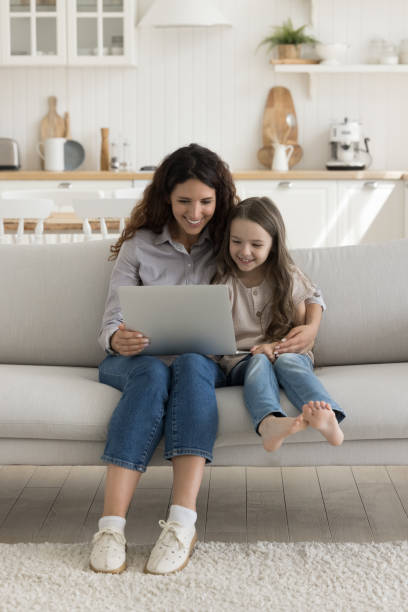 istock Happy mom and cheerful kid girl using laptop 1499522839