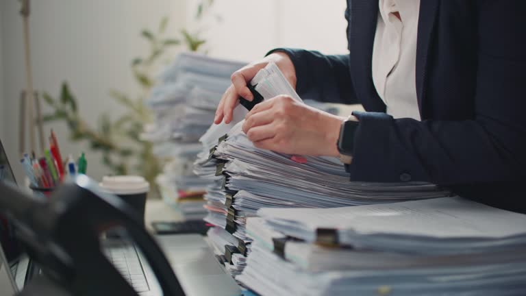 Business person working in the office and piles of paperwork