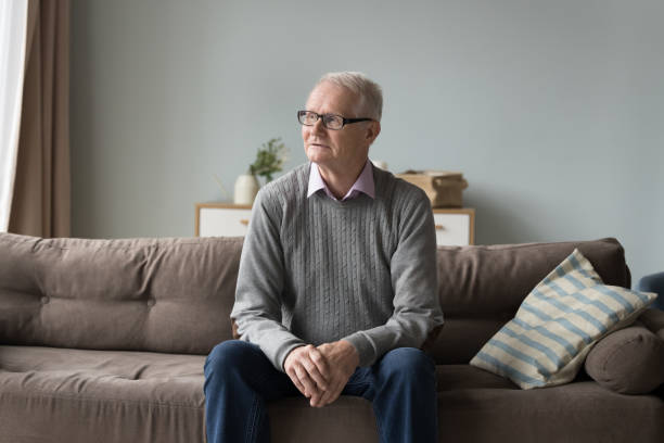 istock Serious pensive senior pensioner man sitting on home couch 1499524922