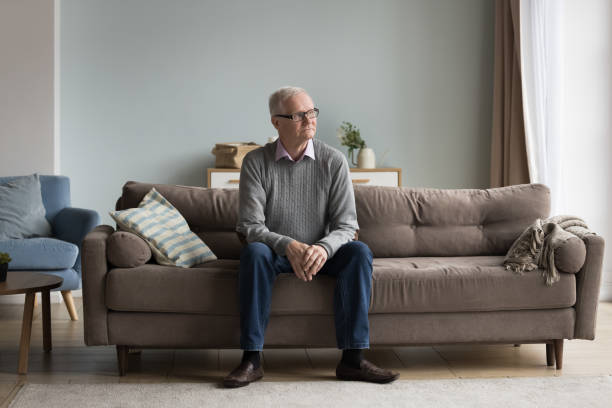 istock Serious thoughtful old pensioner man sitting on home couch 1499524930