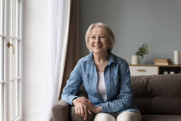 istock Happy pretty elder senior 60s woman sitting on comfortable couch 1499524931