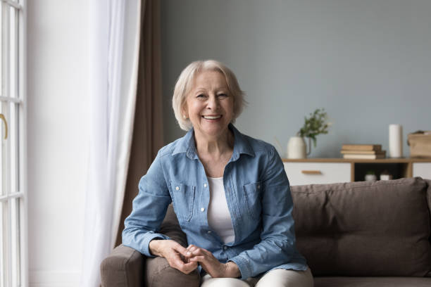 istock Joyful positive senior lady sitting on sofa, smiling, laughing 1499524940