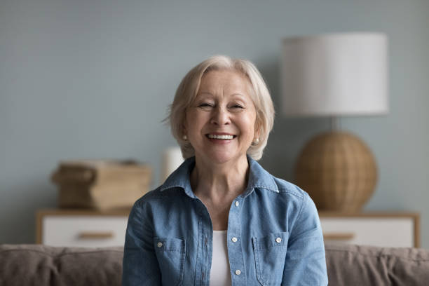 istock Happy cheerful elderly lady looking at camera with toothy smile 1499524949