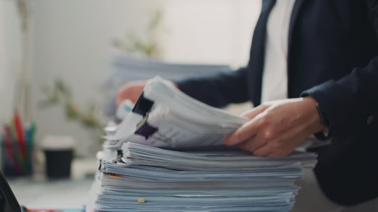 Business person searching for documents on Stack of Document