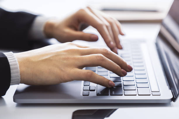 istock With a blurred office environment in the backdrop, the image focuses on a woman's hands typing on a state-of-the-art laptop keyboard 1499530707