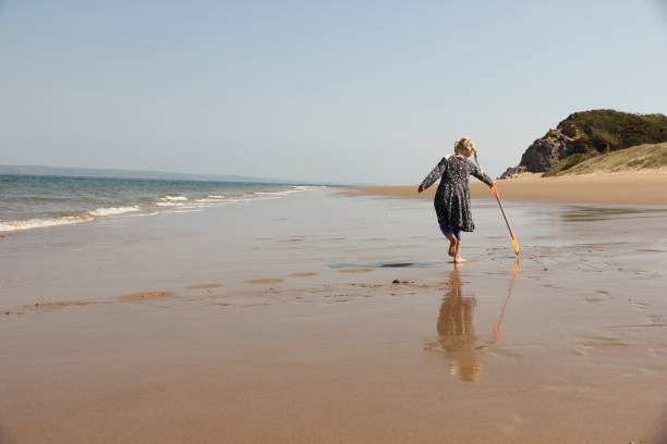istock Little girl walking on reflective beach 1499537010