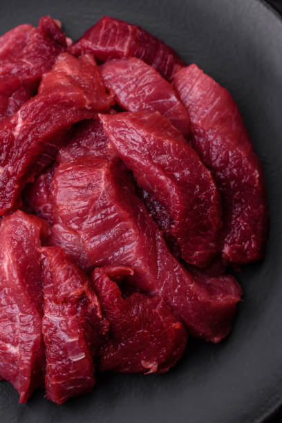 istock Juicy raw beef with spices, salt and herbs on a dark concrete background 1499547685