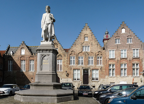 Brugge, Belgium - March 15th 2012: On the 'woensdagmarkt' square stands a statue of 15th century painter Hans Memling, who spent the last part of his life in the city. It was made by Hendrik Pickery and placed there in 1871.