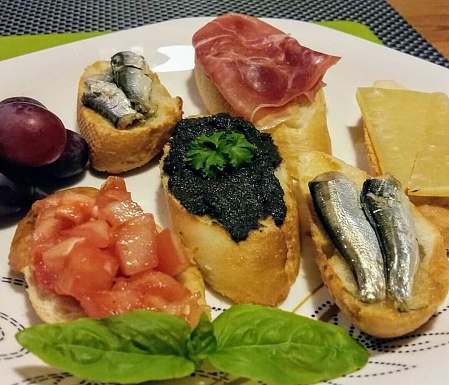 A canapé is a type of hors d'oeuvre, a small, prepared, and often decorative food, consisting of a small piece of bread (sometimes toasted) or cracker, wrapped or topped with some savoury food, held in the fingers and often eaten in one bite