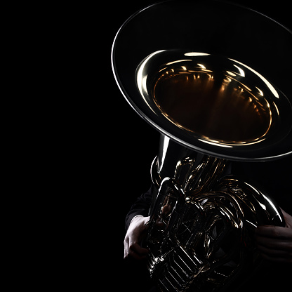 Close-up view of musicians playing trombones. Focus on the foreground, trombone bell.