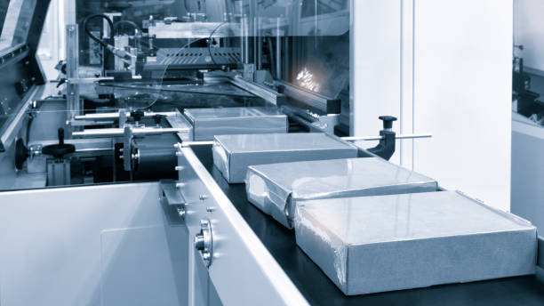 istock Automatic industrial machine for plastic packaging with light effect of products and food. automated packaging line with plastic film in a light blue scene. product packaging concept 1499563237