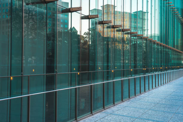 Abstract modern architecture background with geometric structure. Modern glass building mirror reflections. Green tones