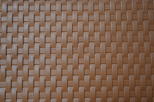 abstract background of a wicker pattern on a wicker plastic chair.