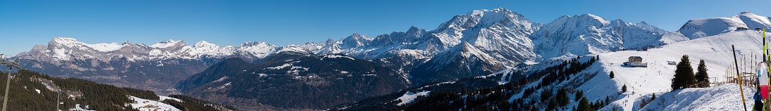 A majestic snow-capped Mont Blanc mountain range, with lush evergreen trees dotting the landscape