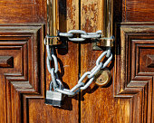 Locked doors, keep out. A large chain and lock preventing entry.