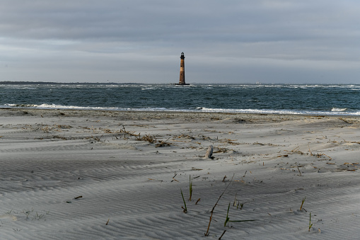 Sand and sea grasses on Folly Beach near Morris Island Lighthouse in Charleston, South Carolina.