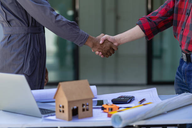 istock A team of construction workers greeted the plan to start a new project contract in the office center at the construction site, concepts, partners and contractors in real estate. 1499581153