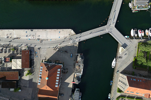 Aerial view of the Transgraven Bridge, a butterfly bicycle bridge between Christianshavns Kanal and Transgraven, connecting the downtown and iconic old town area of Nyhavn on a sunny day in Copenhagen, Denmark