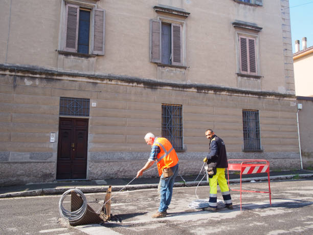 Cremona, Lombardy - May 2023 Internet, phone lines , fiber optic speedy connection installing in old cities. The cable is fed through from long spool. Install conduit for fiber optic cable.