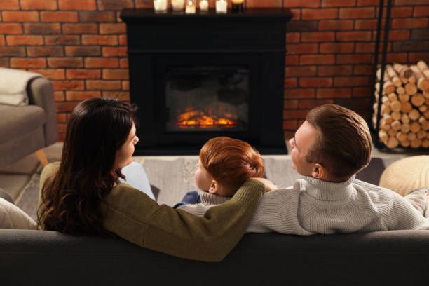 istock Family spending time together on sofa near fireplace at home, back view 1499593185