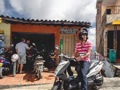 Salento, Colombia, January 4, 2018: A photo of three men outside of a motorcycle shop near Salento, Colombia.