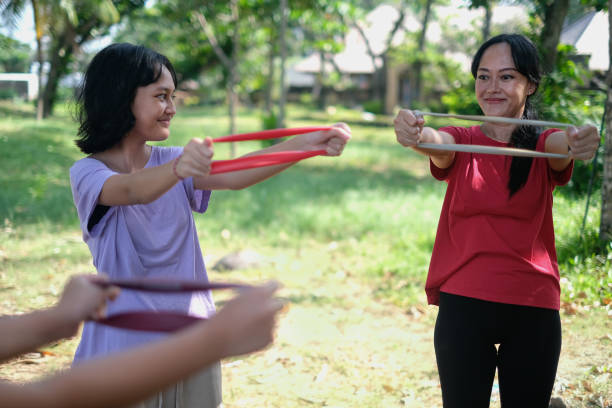 istock Mother and Daughters Using Resistance Band to Exercise Upper Body 1499630797