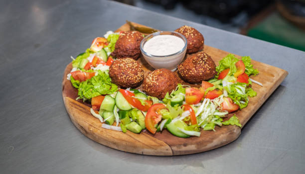 istock Falafel plate with vegetables salad and sauce on the kitchen table close up. 1499636609