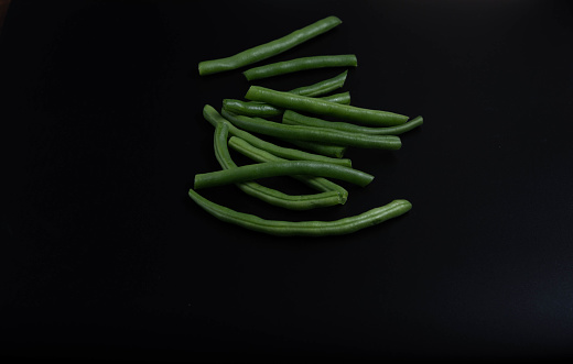 Close-up of green beans, detailed. Healthy food fresh cooking. Close up top view. Raw green beans. Black background.