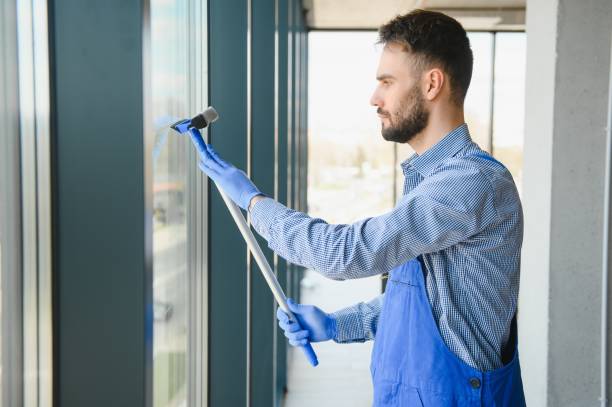 istock Male janitor cleaning window in office 1499646658