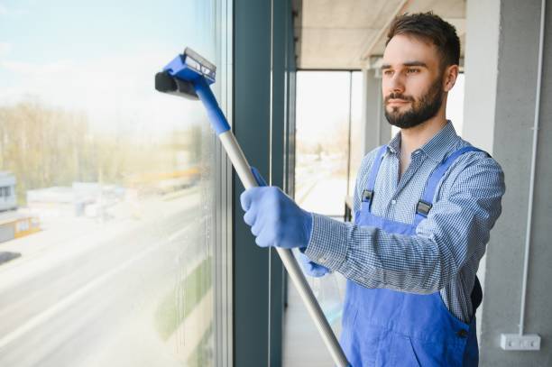 istock Young man cleaning window in office 1499647010