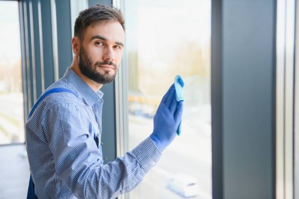 istock Young man cleaning window in office 1499647094