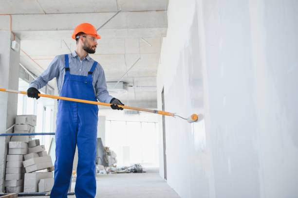 istock painter man painting the wall, with paint roller 1499647431