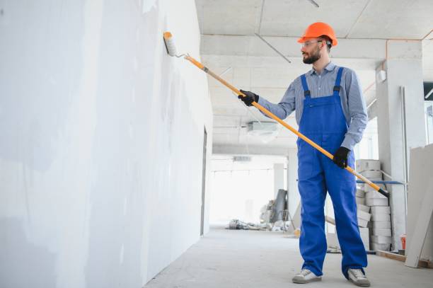 istock painter man painting the wall, with paint roller 1499647432