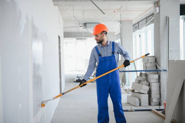 istock painter man painting the wall, with paint roller 1499647444