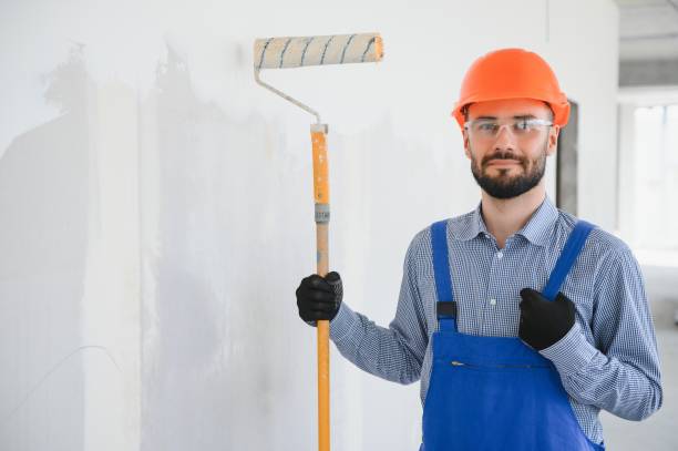 istock painter man painting the wall, with paint roller 1499647453