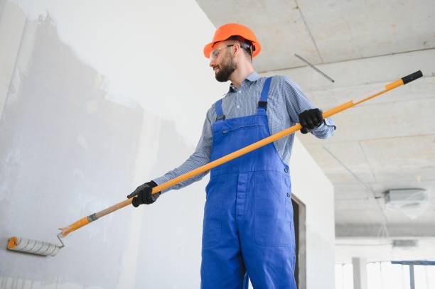 istock painter man painting the wall, with paint roller 1499647465