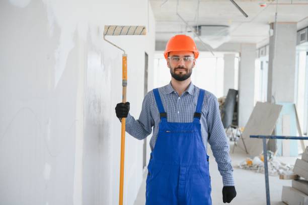 istock painter man painting the wall, with paint roller 1499647466