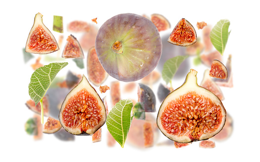 Abstract background made of Fig fruit pieces, slices and leaves isolated on white.