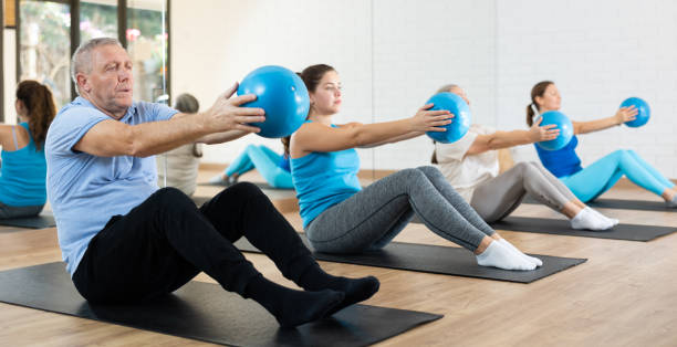 istock Elderly man practicing pilates with ball in gym area 1499659258