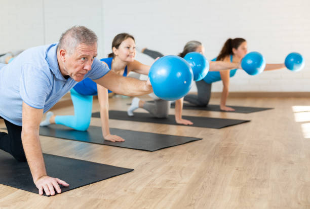istock Elderly man practicing pilates with ball in gym area 1499659264
