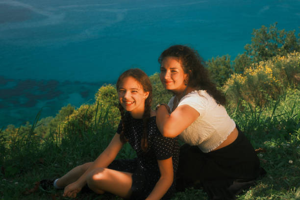 Portrait of two happy sisters hugging in nature