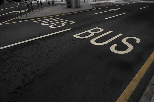 sign on the asphalt, yellow painted numberone on grey street, yellow lines like a corner on the road, space for text