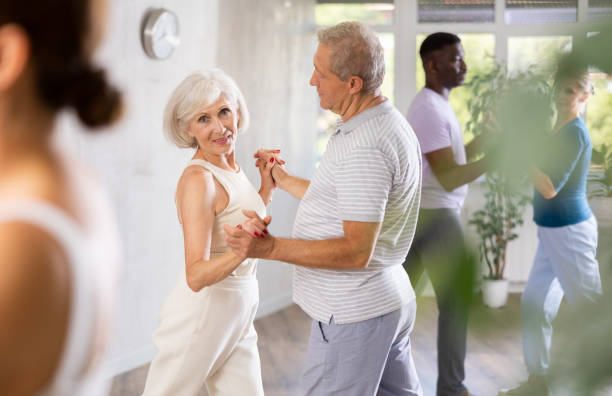 istock Mature men and women practicing Ballroom dances in training room 1499661743